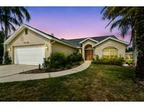 Charming single-story home with a manicured lawn, inviting curb appeal, and attached two-car garage at 5112 Parkway Blvd, Land O Lakes, FL 34639