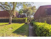 Cozy townhomes showcase mature trees and a well-maintained walking path between units at 705 1St Ct, Palm Harbor, FL 34684