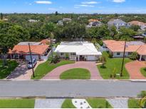 Aerial view of a charming single-Gathering home featuring a beautiful red brick driveway and lush landscaping in a waterfront community at 715 45Th Ne Ave, St Petersburg, FL 33703