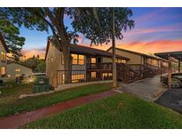 Charming condo featuring a brown roof, well-kept lawn, and beautiful outdoor staircase at 7741 Forest Trl # 6, Port Richey, FL 34668