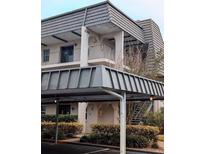 Multi-level condo building featuring a covered parking area and balcony at 8765 Bardmoor Blvd # 108, Seminole, FL 33777