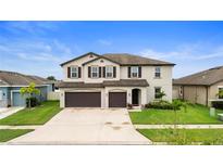 Two-story home featuring a manicured lawn, 2 car garage, and neutral paint at 11719 Tetrafin Dr, Riverview, FL 33579
