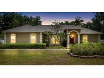 Charming single-story home with a well-manicured lawn and mature landscaping at 12436 Oak St, San Antonio, FL 33576