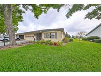 Charming single-story home with landscaped front yard, a two-car garage, and inviting curb appeal at 1417 Langley Dr, Sun City Center, FL 33573