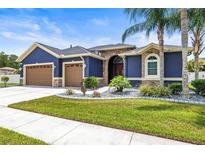 Stunning home with a beautifully landscaped yard, complemented by a two-car garage and elegant stone accents at 1741 Beaconsfield Dr, Wesley Chapel, FL 33543
