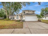 Charming two-story home with a well-manicured lawn, inviting walkway, and attached two-car garage at 1808 Sawhorse Ct, Lutz, FL 33559