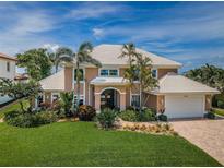 Beautiful two-story home with lush landscaping, tile roof, and a brick driveway at 1988 Carolina Ne Cir, St Petersburg, FL 33703