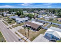 An aerial view of a home with a screened pool, fenced backyard, and palm trees in a residential neighborhood at 260 Venice East Blvd, Venice, FL 34293