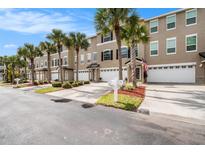 Charming townhomes featuring well-manicured lawns, palm trees, and convenient two-car garages with driveways at 3147 Oyster Bayou Way, Clearwater, FL 33759