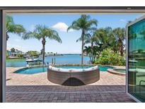 Beautiful waterfront view from the patio with a pool and a comfortable lounge area at 511 Island Way, Clearwater Beach, FL 33767