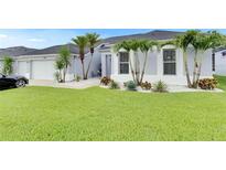 Charming home featuring lush green lawn, complemented by palm trees and beautiful white rock landscaping at 5117 Whispering Leaf Trl, Valrico, FL 33596