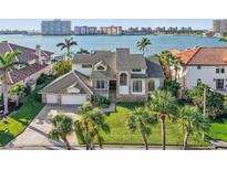 Beautiful waterfront home with lush landscaping and a spacious three-car garage in a tropical paradise at 5287 61St S Ave, St Petersburg, FL 33715