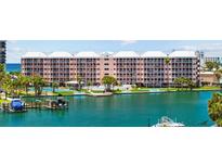 Waterfront condo building with private docks and amenities under a bright sunny sky at 5445 Gulf Blvd # 210, St Pete Beach, FL 33706