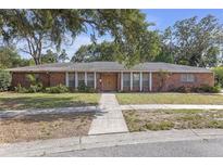 Sprawling brick ranch-style home with mature landscaping and a charming front entrance at 7002 Doreen St, Tampa, FL 33617