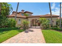 Mediterranean-style home featuring a tile roof, arched entryway, and brick driveway at 841 Ponce De Leon Dr, St Petersburg, FL 33715