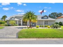 Charming single-story home with manicured lawn, mature landscaping, and a circular driveway at 9276 Ashley Dr, Weeki Wachee, FL 34613