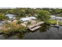 Waterfront home with a private dock, wood deck, and lush landscaping offering serene views at 12 Bayou Ln, Palm Harbor, FL 34683