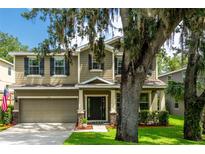 Two-story home with a two-car garage, neutral siding, black shutters and a lovely lawn at 12208 Mcmullen Loop, Riverview, FL 33569