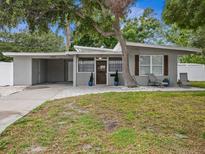 Charming single-story home featuring neutral paint, covered parking, and a quaint front yard at 1242 74Th N St, St Petersburg, FL 33710