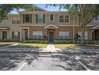 Townhouse exterior featuring neutral colors, manicured landscaping, and well-maintained facade at 12437 Foxmoor Peak Dr, Riverview, FL 33579