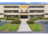 Condo building exterior with well-maintained landscaping, sidewalks, and covered parking at 13612 S Village Dr # 5201, Tampa, FL 33618