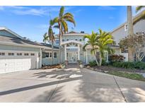 Beautiful two story home featuring a grand entrance, lush landscaping, and a spacious three car garage at 17077 Dolphin Dr, North Redington Beach, FL 33708
