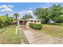 Charming single-story home featuring a concrete driveway, lush lawn, and mature trees at 3035 Hillview St, Sarasota, FL 34239