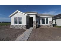 Charming single-story home with stone accents, a paved walkway, and a well-lit entrance at 316 Vistera Blvd, Nokomis, FL 34275