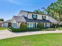 Charming two-story home with manicured landscaping, black shutters, and a long concrete driveway at 3724 Fawn Grove Ct, Land O Lakes, FL 34639