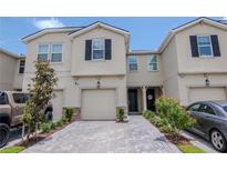 Charming townhome featuring a garage, a paved driveway, and neatly landscaped front yard at 4262 Cloud Hopper Way, Lutz, FL 33559
