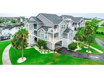 Condominium with a parking garage, marina and landscaping, including palm trees and green grass at 5712 Biscayne Ct # 201, New Port Richey, FL 34652
