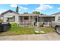 Charming single-story home featuring a covered porch with white picket fence, and landscaped front yard at 6807 N Himes Ave, Tampa, FL 33614