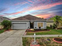 Charming single-story home with a well-maintained lawn, fresh landscaping, and a two-car garage at 7611 Wood Violet Dr, Gibsonton, FL 33534