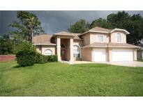 Inviting two-story home featuring a well-manicured lawn, attached two-car garage, and a neutral color palette at 10402 Ashley Oaks Drive, Riverview, FL 33578