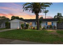 Charming single-story home with lush lawn, mature landscaping, and attached garage at 12359 82Nd N Ave, Seminole, FL 33772