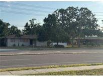 Charming single-story home with mature trees and a well-maintained lawn at 14165 Walsingham Rd, Largo, FL 33774