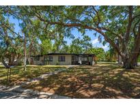 Charming single-story home with a lush, tree-filled front yard, offering shade and curb appeal at 1501 Howard Pl, Largo, FL 33770