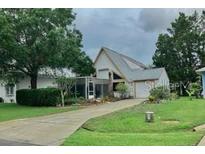 Charming single-Gathering home features a unique architectural design, lush landscaping, and a well-maintained front yard at 20989 Negril, Lutz, FL 33558
