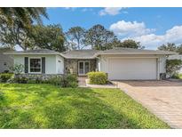 Charming home with stone accents, brick driveway, and well-manicured lawn at 2222 Westchester Blvd, Spring Hill, FL 34606