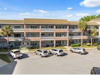 Three story condo building featuring brick accents, ample parking, and well-maintained landscaping at 2461 Rhodesian Dr # 47, Clearwater, FL 33763