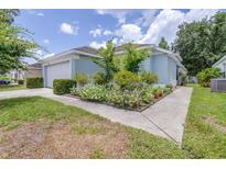 Charming single Gathering home with a well-maintained lawn, flower garden, and attached two car garage at 26343 Whirlaway Ter, Wesley Chapel, FL 33544