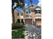 Charming two-story townhome featuring a two-car garage and manicured front yard at 26541 Chimney Spire Ln, Wesley Chapel, FL 33544