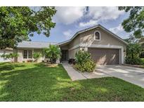 Charming single-story home featuring a well-manicured lawn, a two-car garage, and lovely landscaping at 3115 Westridge Dr, Holiday, FL 34691