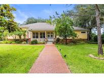 Charming yellow home with a brick walkway and inviting front porch at 3402 Melissa Country Way, Lutz, FL 33559