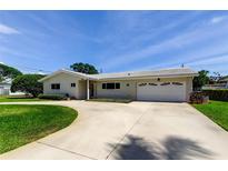 Charming single-story home featuring a well-manicured lawn, circular driveway, and attached two-car garage at 4300 31St N Ave, St Petersburg, FL 33713