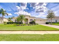 Charming single-story home with a well-manicured lawn and lush, tropical landscaping at 4304 Place Le Manes, Lutz, FL 33558