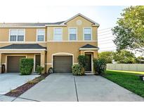 Two-story townhome featuring a one-car garage and a well-maintained front yard with green bushes at 6940 47Th N Way, Pinellas Park, FL 33781