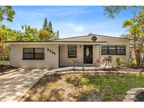 Charming single story home featuring updated paint, landscaping, and a well-manicured front lawn at 8009 Somerset Ln, Tampa, FL 33615