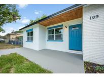 Charming home featuring a blue front door and wood plank awning at 109 Magnolia Ave, Seffner, FL 33584