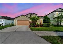 Charming single-Gathering home with lush landscaping and a two-car garage at 11837 Thicket Wood Dr, Riverview, FL 33579